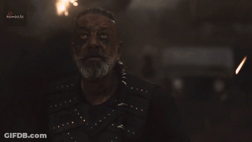 A Man With A Beard And A Black Shirt Is Looking At The Camera With A Blurred Background That Says Kimbal.co GIF