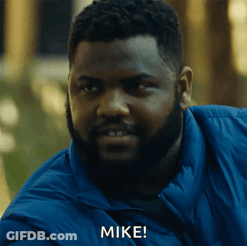 A Man With A Beard And A Blue Jacket Is Saying Mike GIF