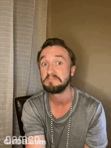 A Man With A Beard And A Cameo Logo On The Bottom Right GIF