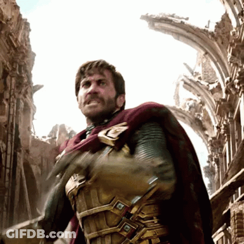 A Man With A Beard And A Cape Is Standing In Front Of A Ruined Building GIF