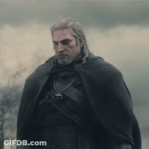 A Man With A Beard And A Cape Is Standing In The Fog . GIF