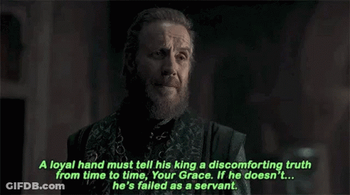 A Man With A Beard And A Chain Around His Neck Is Talking To Another Man . GIF
