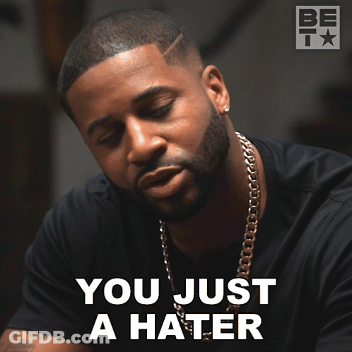 A Man With A Beard And A Chain Around His Neck Says " You Just A Hater " GIF