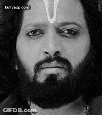 A Man With A Beard And A Cross On His Forehead Is Making A Funny Face . GIF