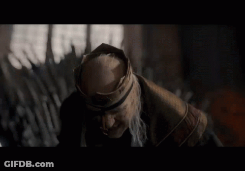 A Man With A Beard And A Crown On His Head Looks To The Side GIF