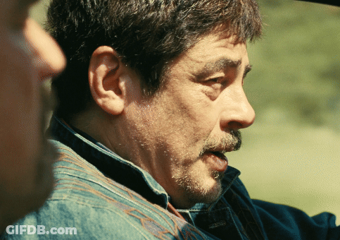 A Man With A Beard And A Denim Shirt Is Talking To Another Man GIF