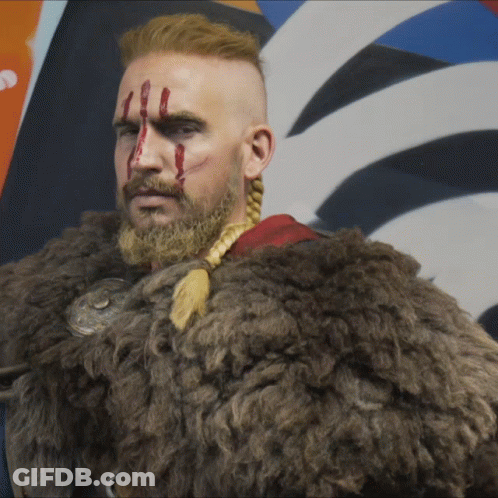 A Man With A Beard And A Fur Coat Has Blood Dripping From His Face GIF