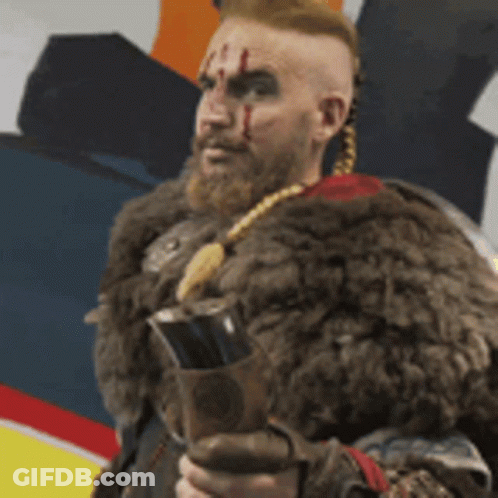 A Man With A Beard And A Fur Coat Is Holding A Sword . GIF