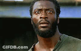 A Man With A Beard And A Green Shirt Is Looking At The Camera With A Surprised Look On His Face . GIF