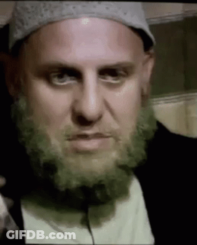 A Man With A Beard And A Hat Is Making A Face . GIF