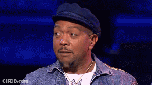 A Man With A Beard And A Hat Is Making A Funny Face . GIF