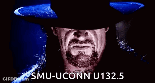 A Man With A Beard And A Hat Is Making A Funny Face And Saying Smu-Uconn U132.5 . GIF