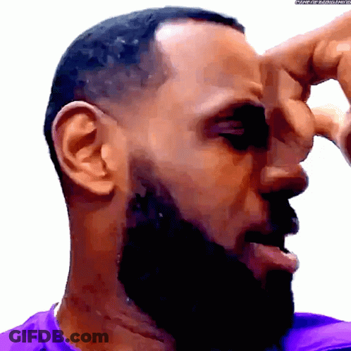 A Man With A Beard And A Purple Shirt Scratching His Nose GIF