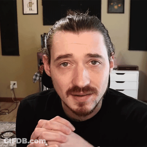 A Man With A Beard And A Ring On His Finger Is Looking At The Camera GIF