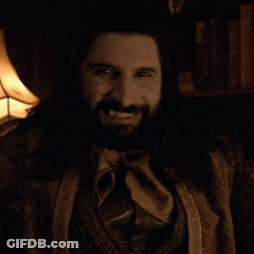 A Man With A Beard And A Ring On His Finger Smiles For The Camera GIF