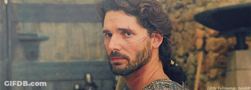 A Man With A Beard And A Scar On His Face Is Looking Over His Shoulder At Something GIF