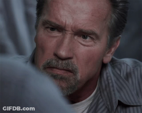 A Man With A Beard And A Striped Shirt Looks Angry GIF