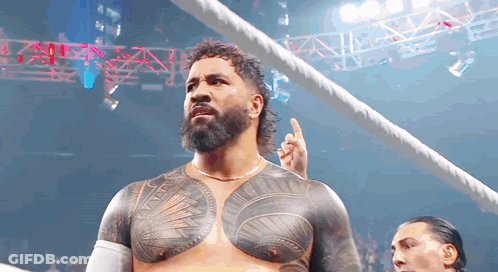 A Man With A Beard And A Tattoo On His Chest Is Standing In A Ring . GIF