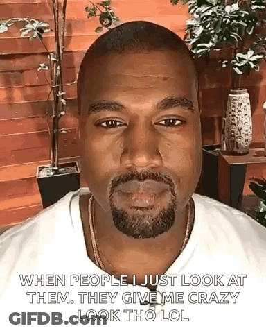 A Man With A Beard And A White Shirt Is Smoking A Cigarette And Making A Funny Face . GIF