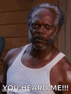 A Man With A Beard And A White Tank Top Is Saying `` You Heard Me ! '' GIF