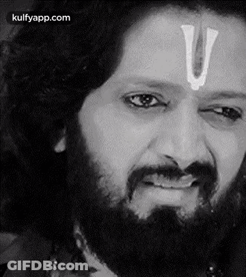 A Man With A Beard And A White U On His Forehead Is Making A Funny Face . GIF