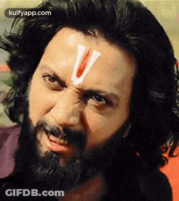 A Man With A Beard And A White V On His Forehead . GIF