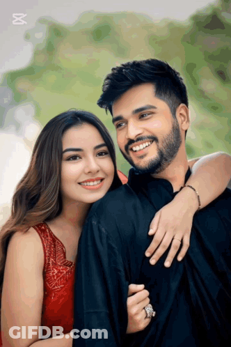 A Man With A Beard And A Woman In A Red Dress Are Posing For A Picture GIF