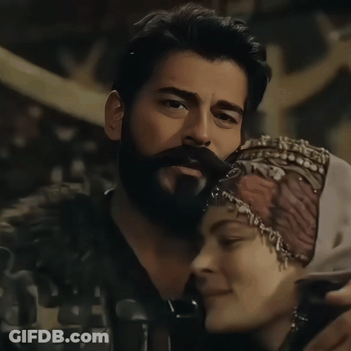 A Man With A Beard And A Woman Wearing A Head Scarf GIF