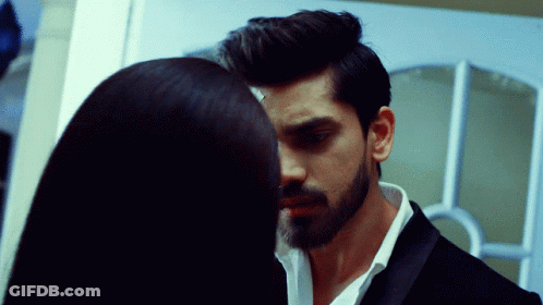 A Man With A Beard And A Woman With Long Hair Are Looking Into Each Other 'S Eyes GIF