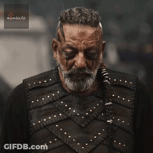 A Man With A Beard And Black Paint On His Face Is Wearing A Black Vest With Studs On It GIF