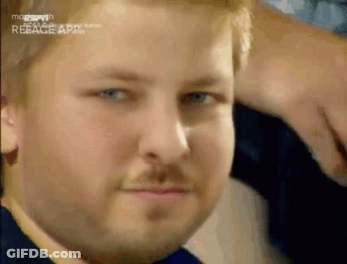 A Man With A Beard And Blue Eyes Is Making A Funny Face . GIF