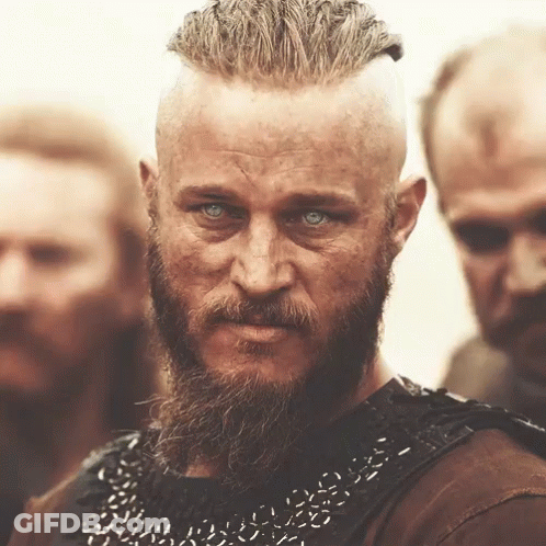 A Man With A Beard And Blue Eyes Stands In A Crowd GIF