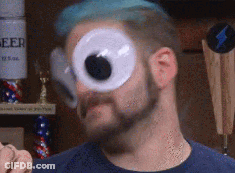 A Man With A Beard And Blue Hair Is Wearing Googly Eyes . GIF