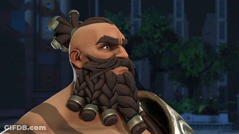 A Man With A Beard And Braided Hair Is Pointing To His Forehead GIF