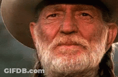 A Man With A Beard And Braids Is Wearing A Cowboy Hat . GIF