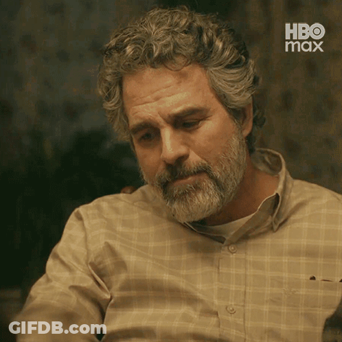 A Man With A Beard And Curly Hair Is Wearing A Plaid Shirt With Hbo Max On The Bottom GIF