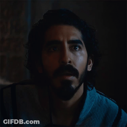 A Man With A Beard And Curly Hair Looks Up Into The Dark GIF