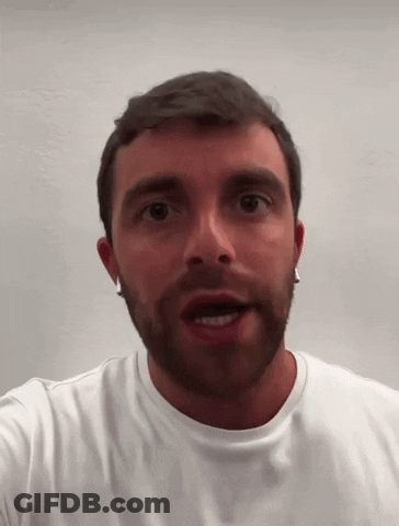 A Man With A Beard And Earrings Is Wearing A White Shirt GIF