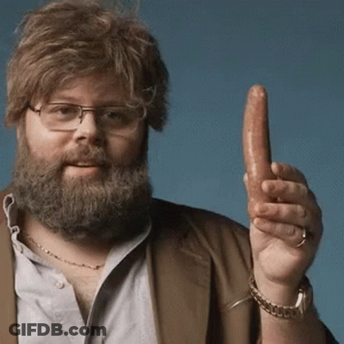 A Man With A Beard And Glasses Is Holding A Sausage In His Hand GIF
