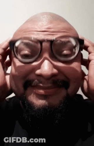 A Man With A Beard And Glasses Is Making A Funny Face GIF