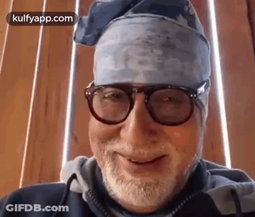 A Man With A Beard And Glasses Is Wearing A Bandana And Smiling . GIF