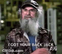 A Man With A Beard And Glasses Is Wearing A Camo Jacket And A Hat . GIF