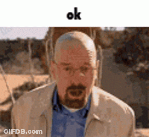 A Man With A Beard And Glasses Is Wearing A Jacket And A Blue Shirt And Says Ok . GIF