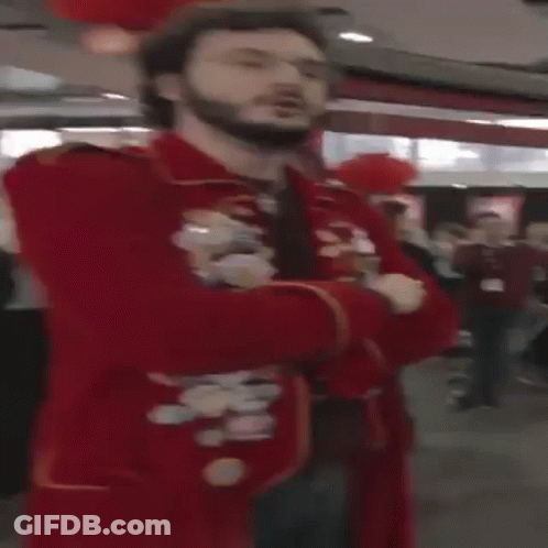 A Man With A Beard And Glasses Is Wearing A Red Jacket GIF
