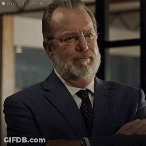A Man With A Beard And Glasses Is Wearing A Suit And Tie With The Hashtag #Diggstown GIF