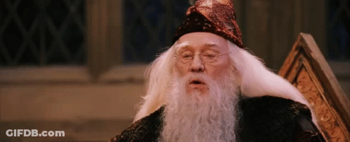 A Man With A Beard And Glasses Is Wearing A Wizard Hat GIF
