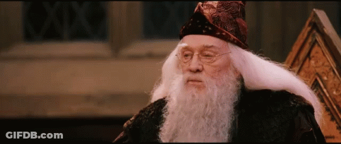 A Man With A Beard And Glasses Is Wearing A Wizard Hat GIF