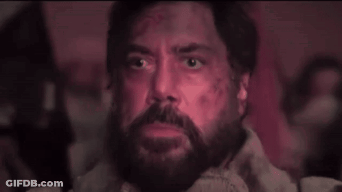 A Man With A Beard And Glowing Eyes Is Looking Up At Something . GIF