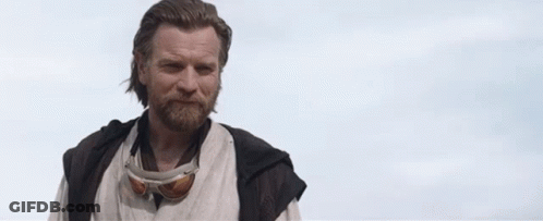 A Man With A Beard And Goggles Is Standing In Front Of A Cloudy Sky And Saying `` Hello There '' . GIF