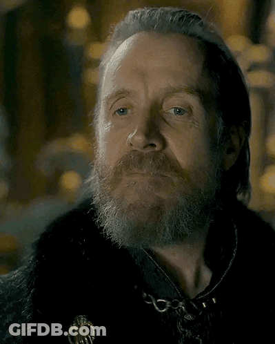 A Man With A Beard And Gray Hair Is Wearing A Black Coat GIF